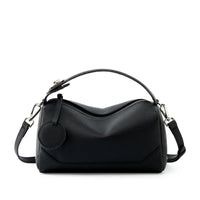 Black leather handbag with top handle and detachable shoulder strap on white background