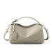 Beige leather handbag with zipper closure and adjustable shoulder strap