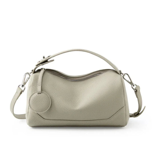 Beige leather handbag with zipper closure and adjustable shoulder strap
