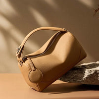 Beige leather handbag with zipper on stone, modern minimalist background