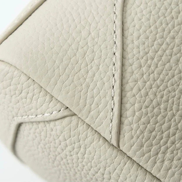 Close-up of textured beige leather with precise stitching detail