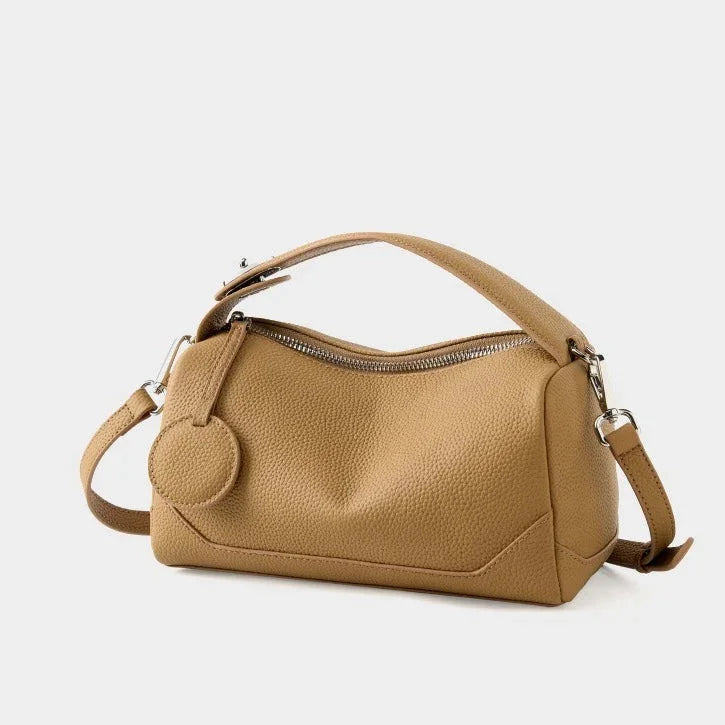 Tan leather shoulder bag with zipper, top handle, and detachable strap on white background