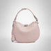 Light pink woven leather handbag with top handle and silver clasp on white background