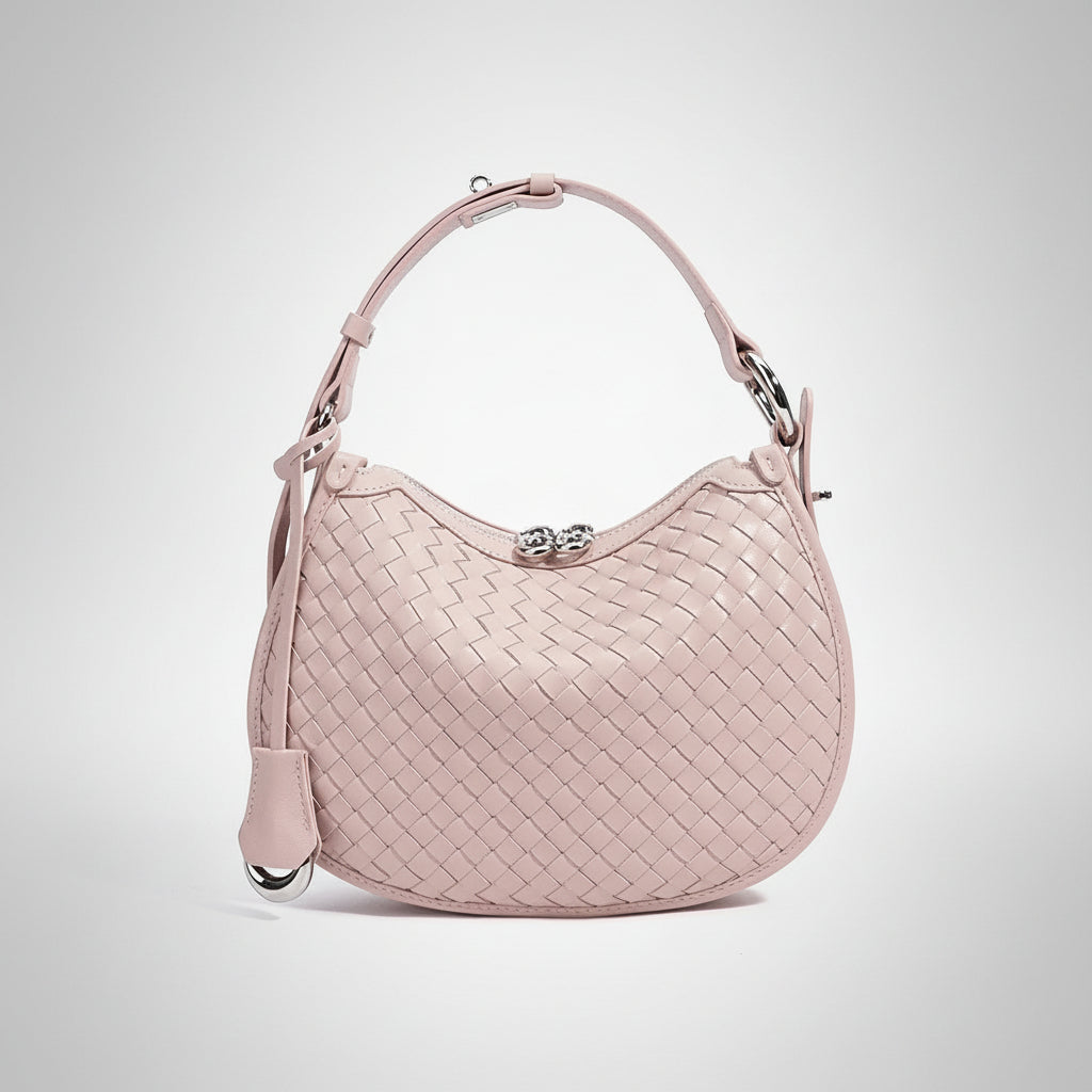 Light pink woven leather handbag with top handle and silver clasp on white background