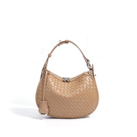 Beige woven leather hobo bag with top handle and silver clasp on white background