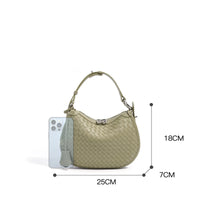 Woven leather handbag in pale green with size dimensions and a smartphone for scale