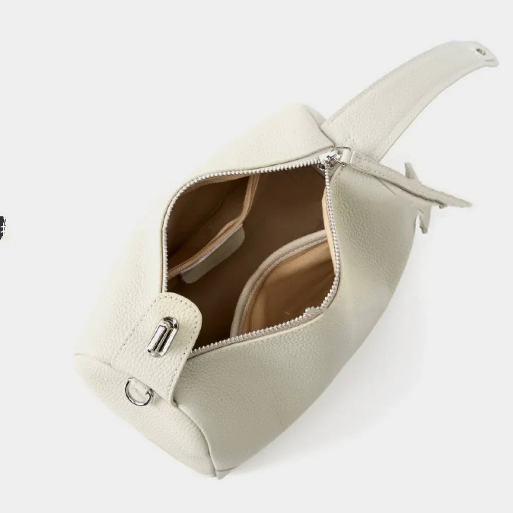 Cream leather crossbody bag with zipper open, showing interior pockets and silver hardware