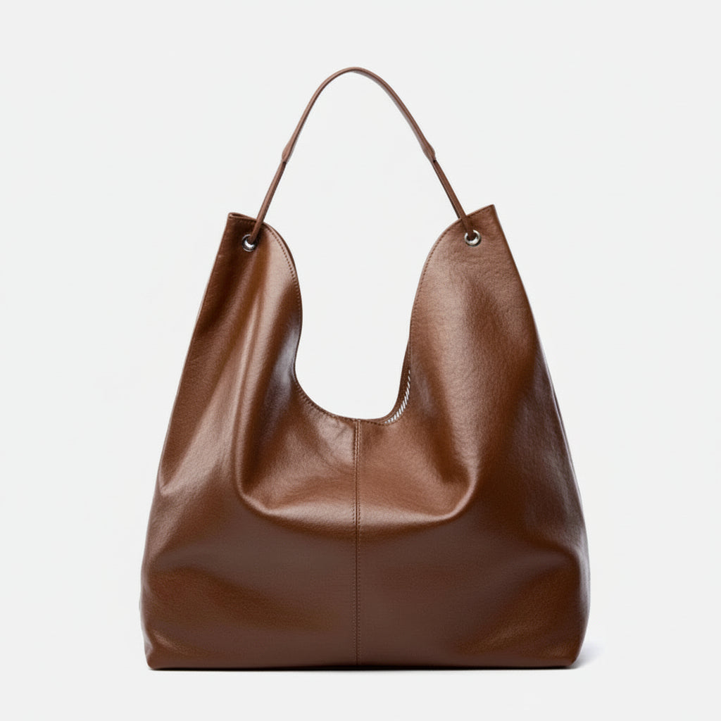 Large brown leather tote bag with single handle on white background