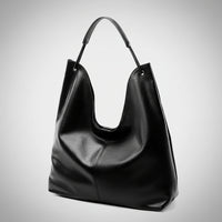 Black leather hobo bag with shoulder strap on plain white background