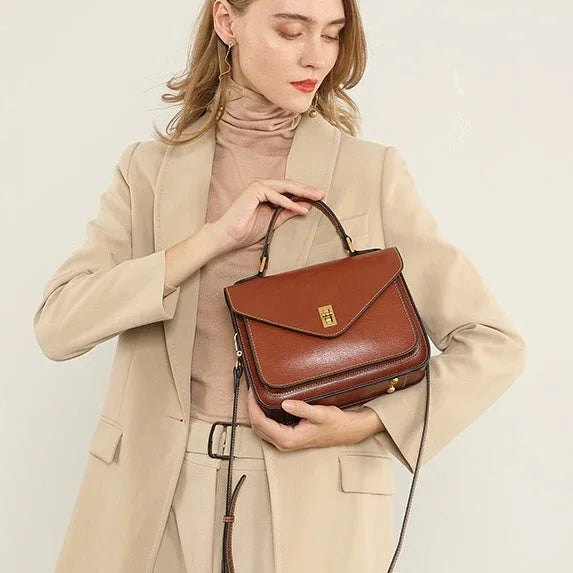 Woman in beige suit holding a brown leather handbag with gold clasp