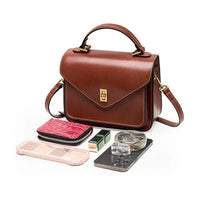 Brown leather crossbody handbag with accessories, wallet, makeup, phone, and perfume bottle