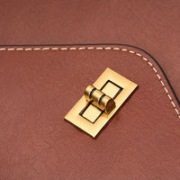 Brown leather bag with gold turn lock closure and white stitched edge
