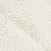 Close-up of cream quilted lizard-embossed leather with visible stitching detail