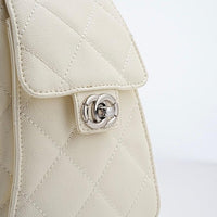 Close-up of quilted cream leather handbag with silver twist-lock clasp