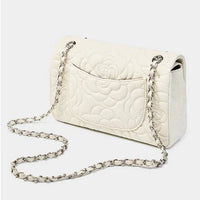 White quilted leather shoulder bag with floral stitching and silver chain strap