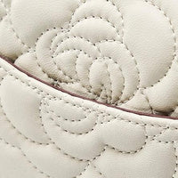Beige leather bag with quilted floral stitching and a curved seam detail