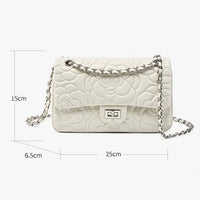 White quilted leather shoulder bag with floral pattern, chain strap, and size dimensions