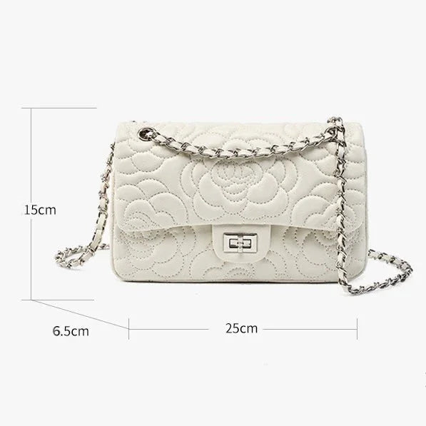 White quilted leather shoulder bag with floral pattern, chain strap, and size dimensions