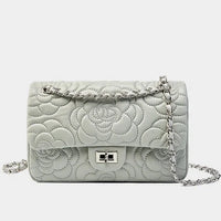 Quilted white leather shoulder bag with silver chain strap and floral pattern