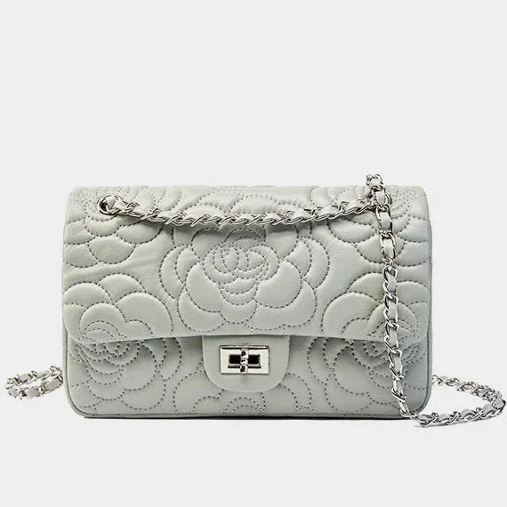 Quilted white leather shoulder bag with silver chain strap and floral pattern