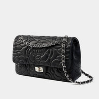 Black quilted leather handbag with floral pattern and silver chain strap