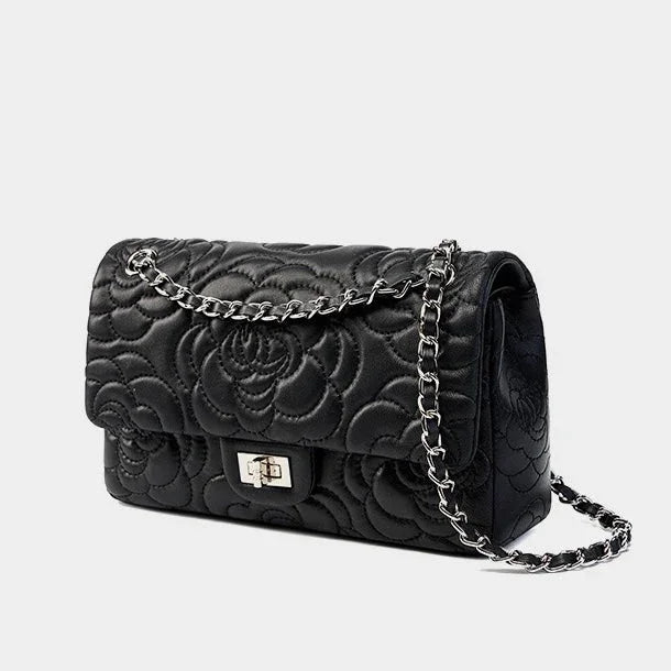 Black quilted leather handbag with floral pattern and silver chain strap