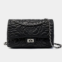 Black quilted leather handbag with floral pattern and silver chain strap