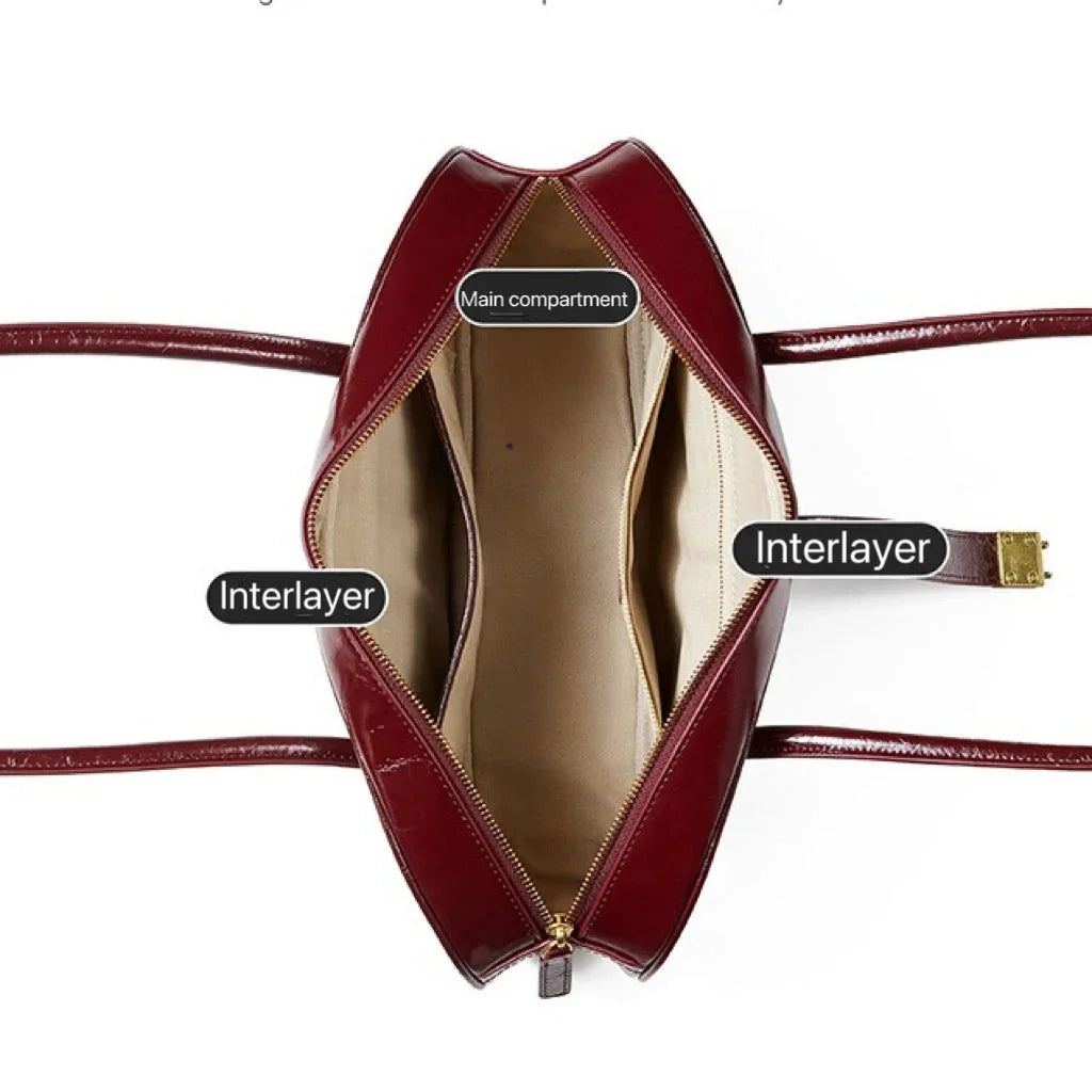 Top view of a burgundy leather handbag showing labeled main compartment and two interlayers