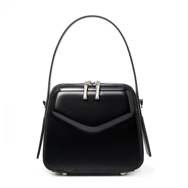 Black square leather handbag with top handle and silver zipper accents on white background