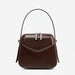 Brown leather handbag with top handle and silver zippers on white background