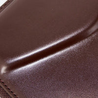 Close-up of smooth brown leather surface with visible stitching detail