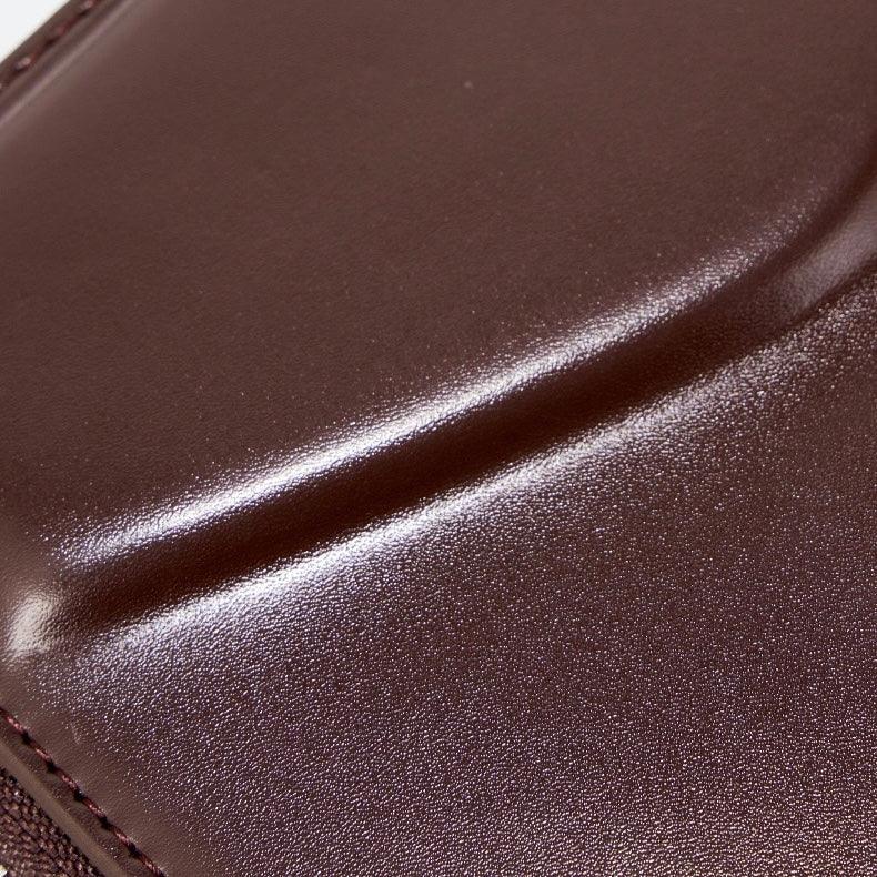 Close-up of smooth brown leather surface with visible stitching detail