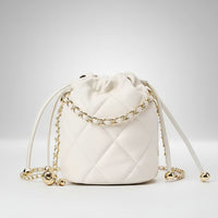 White quilted drawstring bucket bag with gold chain strap and gold accents on a white background.
