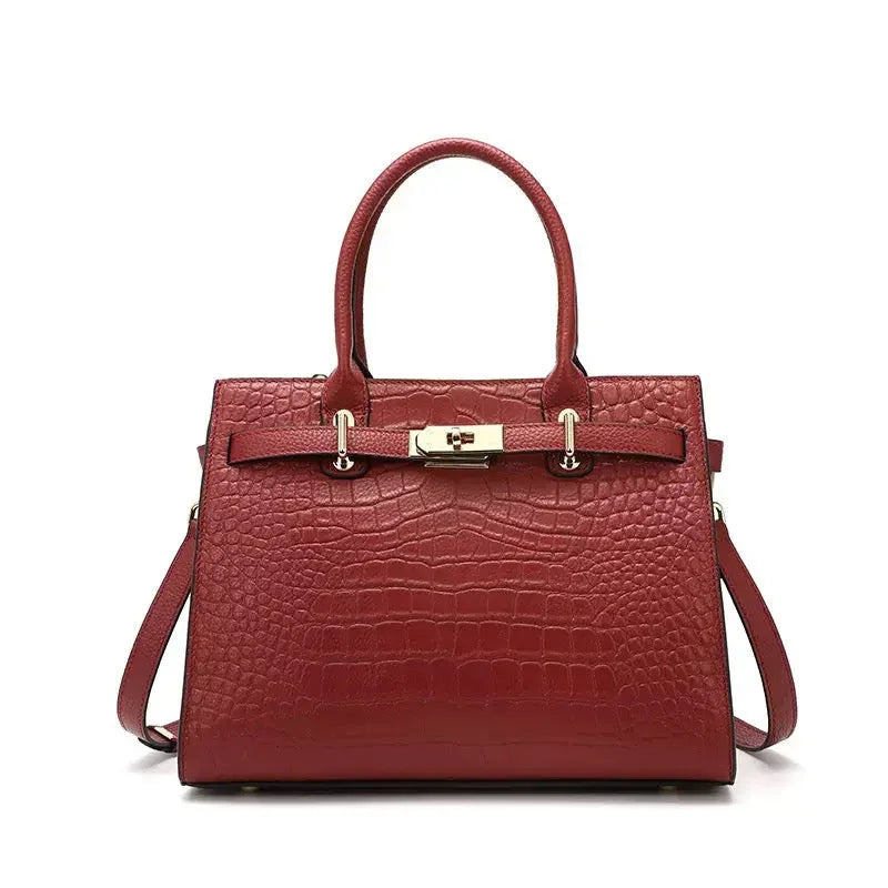 Red crocodile embossed leather handbag with gold hardware and structured top handles