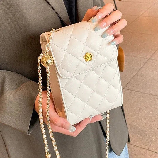 Woman holding quilted white crossbody purse with gold chain strap and clasp