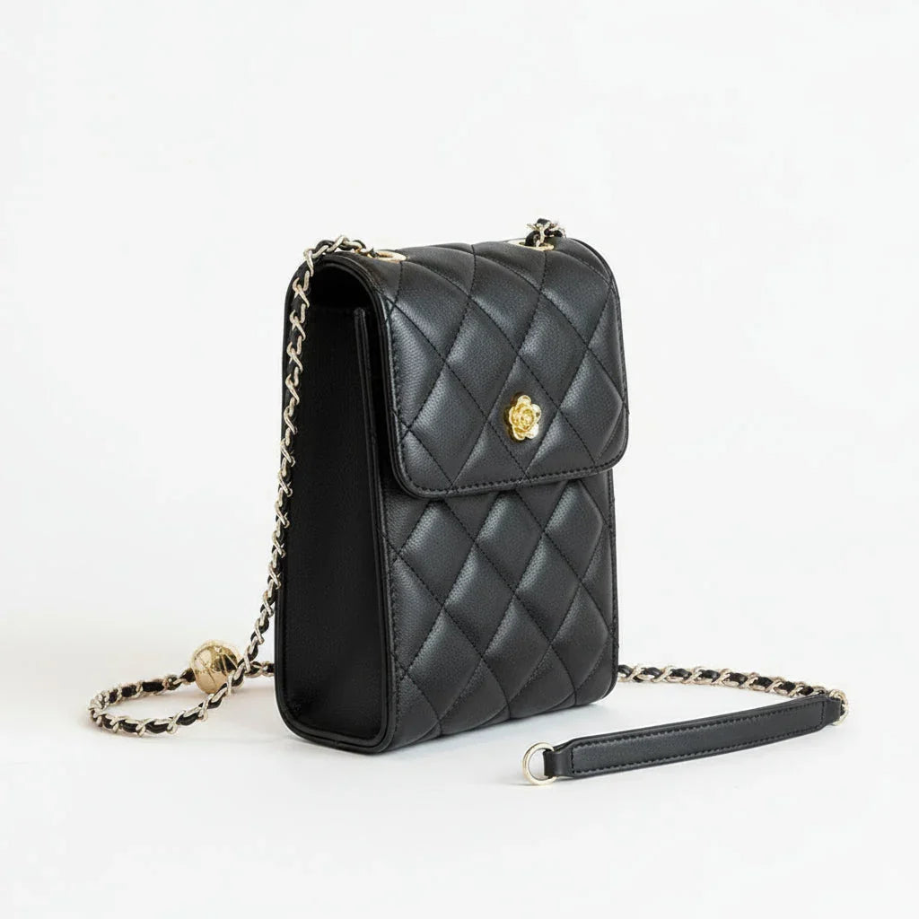Quilted black leather crossbody purse with gold chain strap on white background