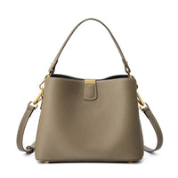 Taupe leather handbag with gold hardware and detachable shoulder strap on white background