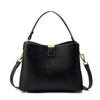 Black leather handbag with gold hardware and removable shoulder strap on white background