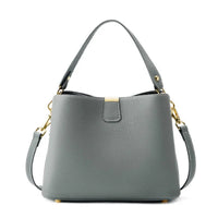 Gray leather handbag with gold hardware and detachable shoulder strap on white background