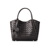 Black woven leather tote bag with double handles and an elephant-shaped charm
