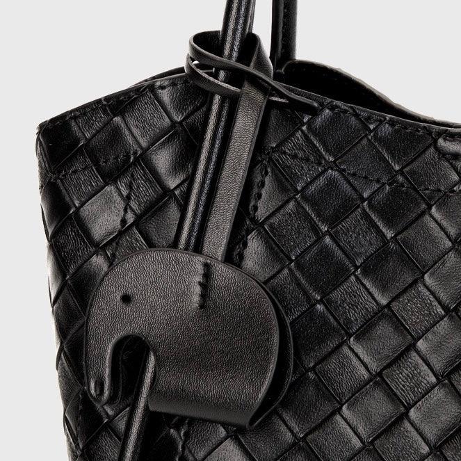 Black woven leather handbag with elephant-shaped leather charm detail