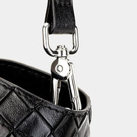 Black leather quilted bag with silver hardware and clasp detail on a light background