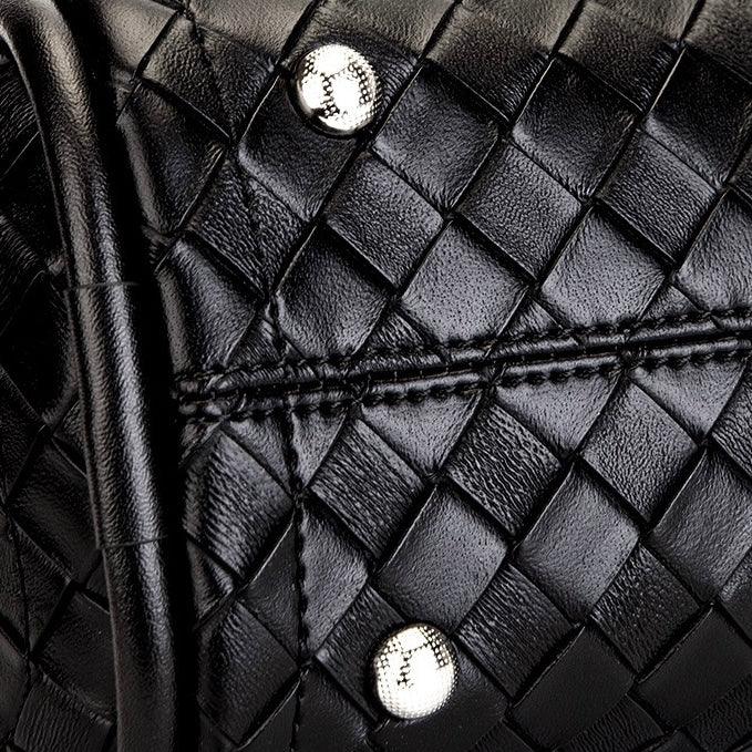 Close-up of black woven leather bag with silver rivets and visible stitching detail