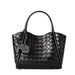 Black woven leather tote bag with dual handles and attached decorative tag