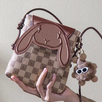 Brown checkered crossbody bag with bunny face design and plush bear keychain