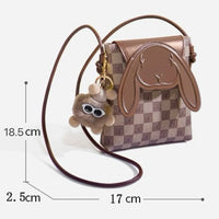 Cute brown checkered crossbody bag with bunny face, plush keychain, and size dimensions.
