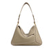 Beige leather shoulder bag with top handle, white stitching, gold hardware on white background