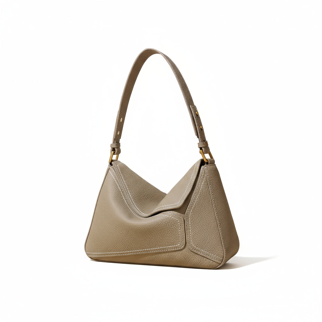 Taupe leather shoulder bag with gold hardware on a neutral background