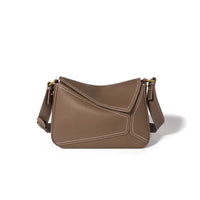 Brown leather shoulder bag with white stitching and gold hardware on white background