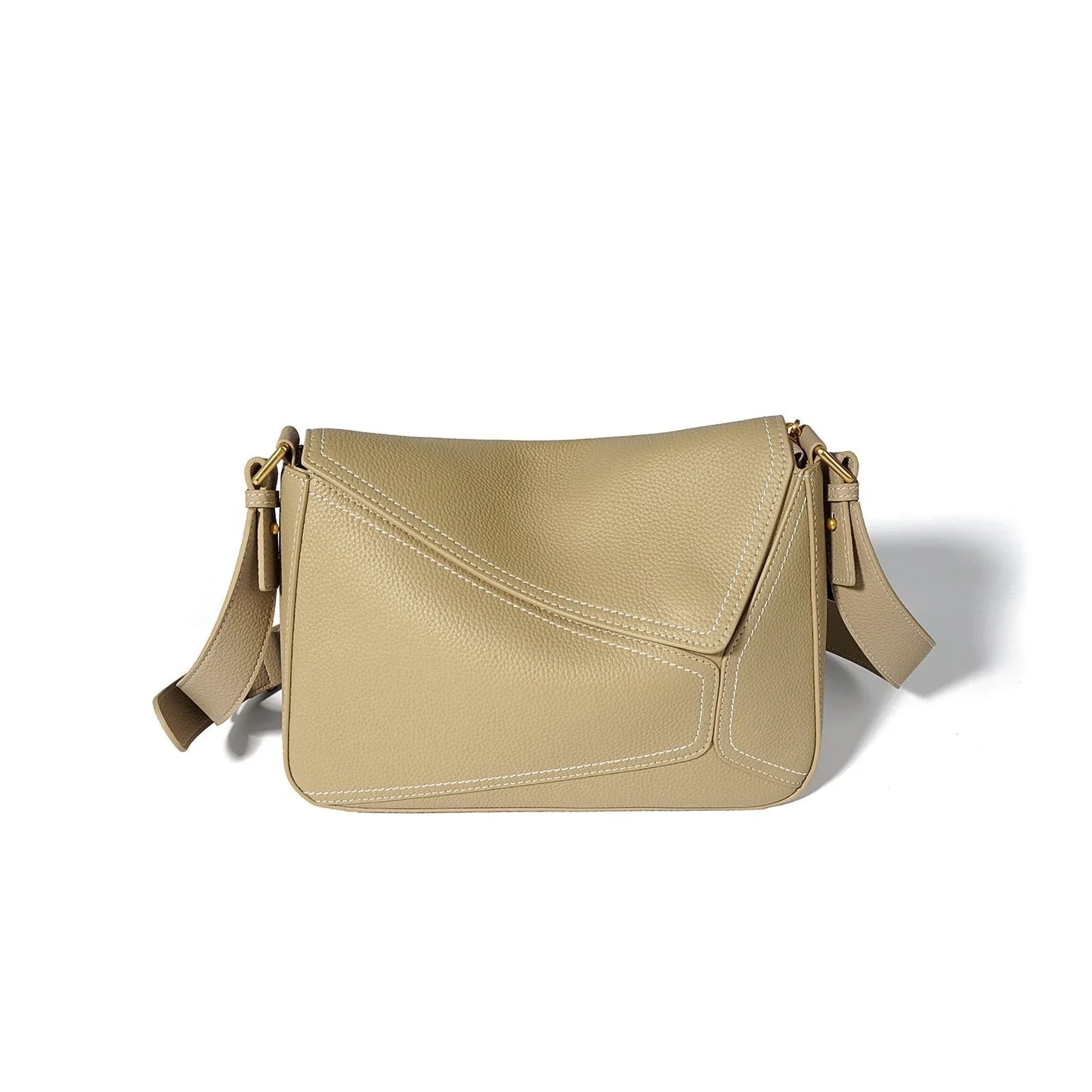 Beige leather crossbody bag with geometric stitching and adjustable strap on white background